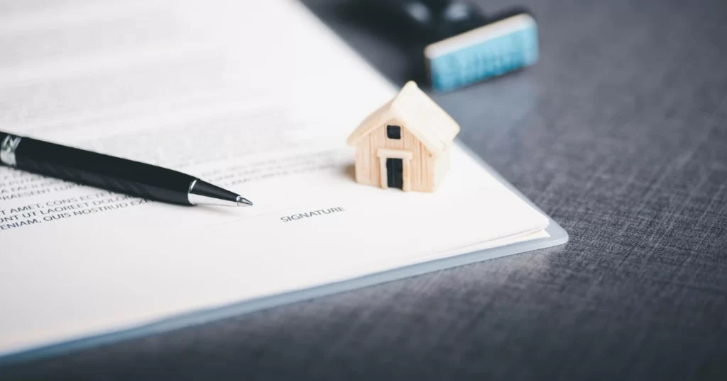 Um contrato com a palavra "SIGNATURE" e uma caneta, simbolizando o investimento em fundos imobiliários como uma alternativa para investir em imóveis sem os trâmites burocráticos de uma compra física.