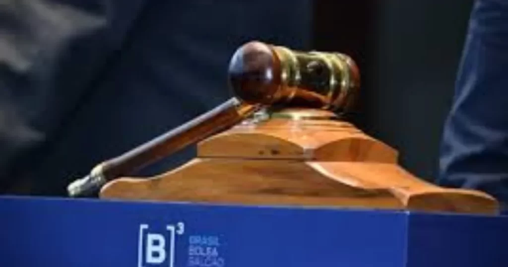 Um martelo de leilão sobre a mesa da bolsa de valores B3, simbolizando a seriedade e o rigor da análise de balanços para a tomada de decisões de investimento.