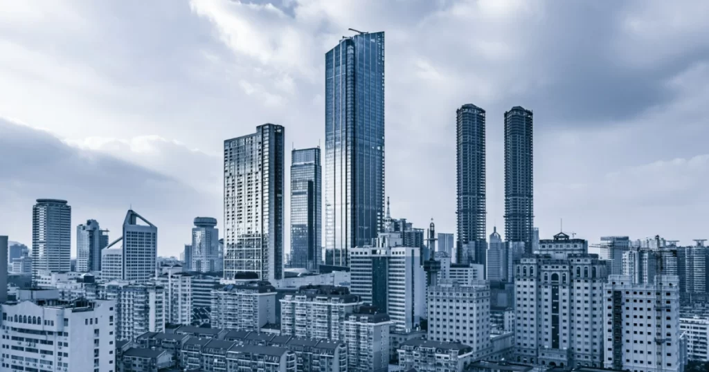 Imagem de prédios e arranha-céus, simbolizando os ativos de um fundo de investimento imobiliário (FII) e o conceito de investir em imóveis sem comprá-los diretamente.