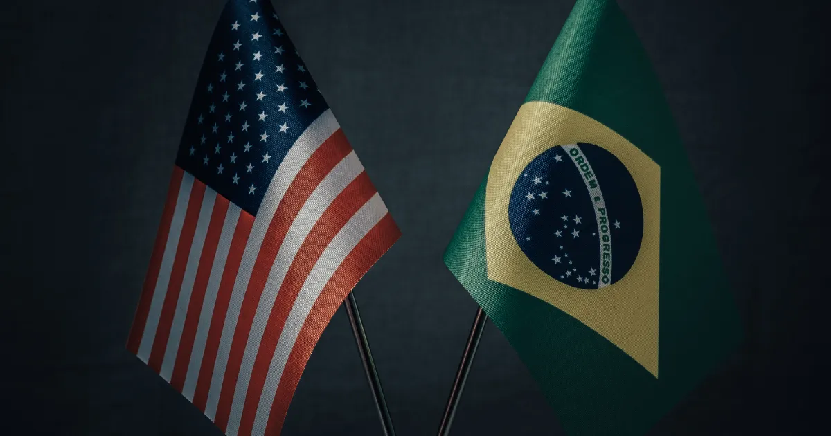 Duas bandeiras, a dos Estados Unidos e a do Brasil, lado a lado, simbolizando a relação comercial e os acordos entre os dois países.