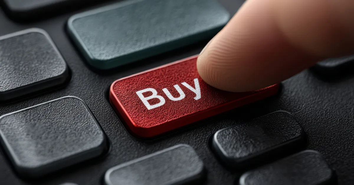 Um dedo pressionando um botão vermelho com a palavra "Buy" (Comprar) em um teclado preto, simbolizando a ação de entrar em uma operação de compra seguindo um sinal de trading.