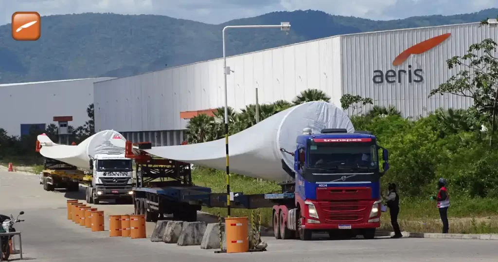 Fábrica da Aeris Energy (AERI3) no Complexo do Pecém com caminhões transportando pás eólicas gigantes