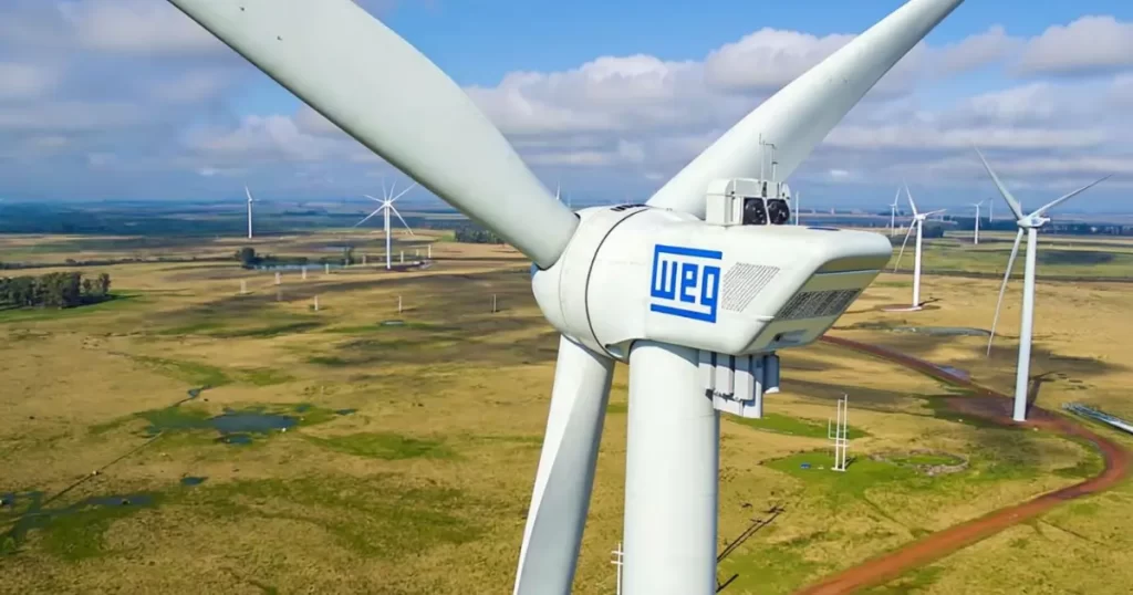 Dividendos em Dezembro: Aerogerador WEG em parque eólico com várias turbinas de energia renovável ao fundo