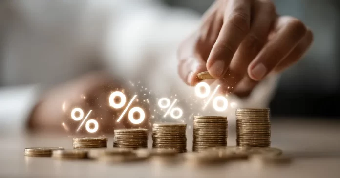 Mão empilhando moedas em ordem crescente com símbolos de porcentagem representando crescimento de investimentos em FIIs e renda passiva