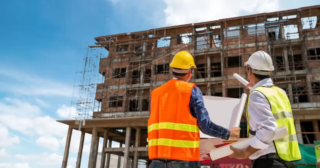 Engenheiros analisando projeto de construção de prédio representando FIIs de tijolo e fundos de desenvolvimento imobiliário