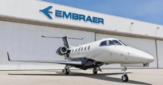 Avião Embraer estacionado em frente ao hangar com logo da empresa — EMBJ3 em região de suporte técnico